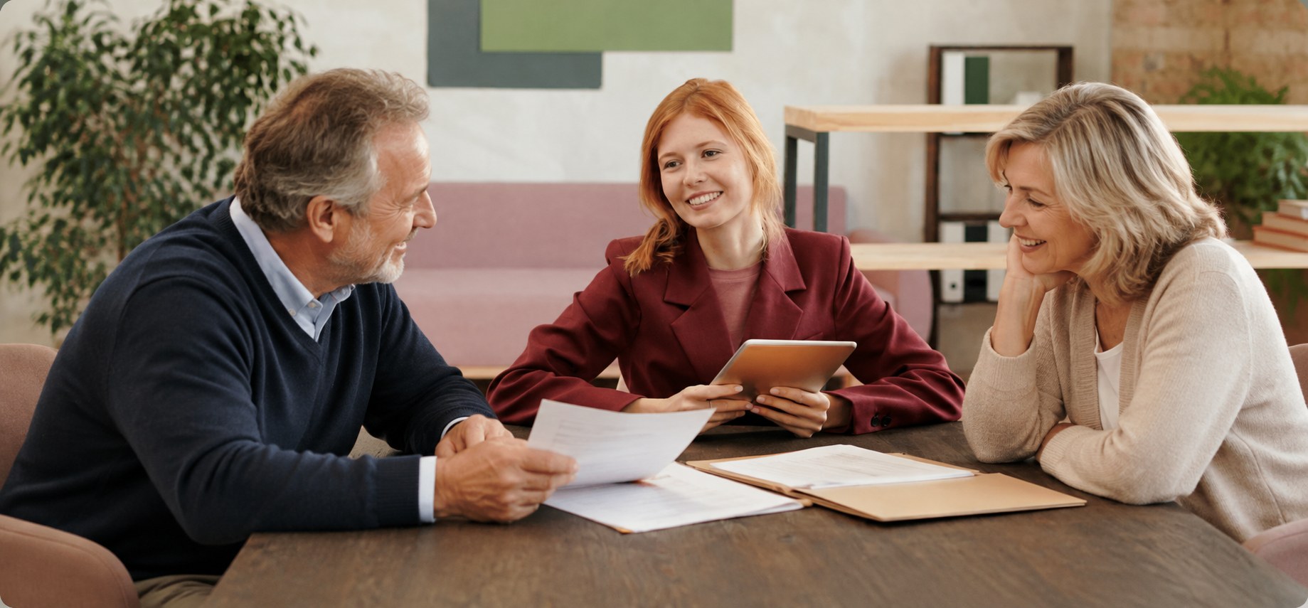 An adult daughter reviewing paperwork with her parents at a table