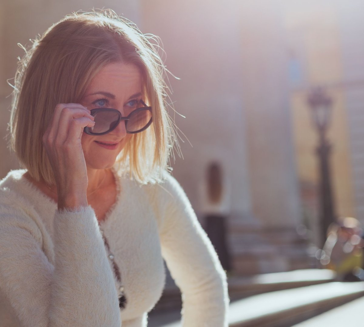 A woman in sunglasses enjoying a sunny day in the city