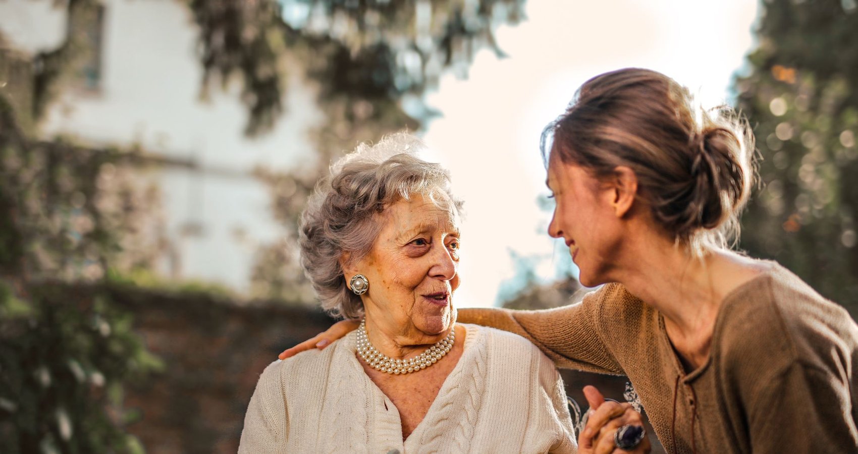 A daughter laughing with her mother outdoors