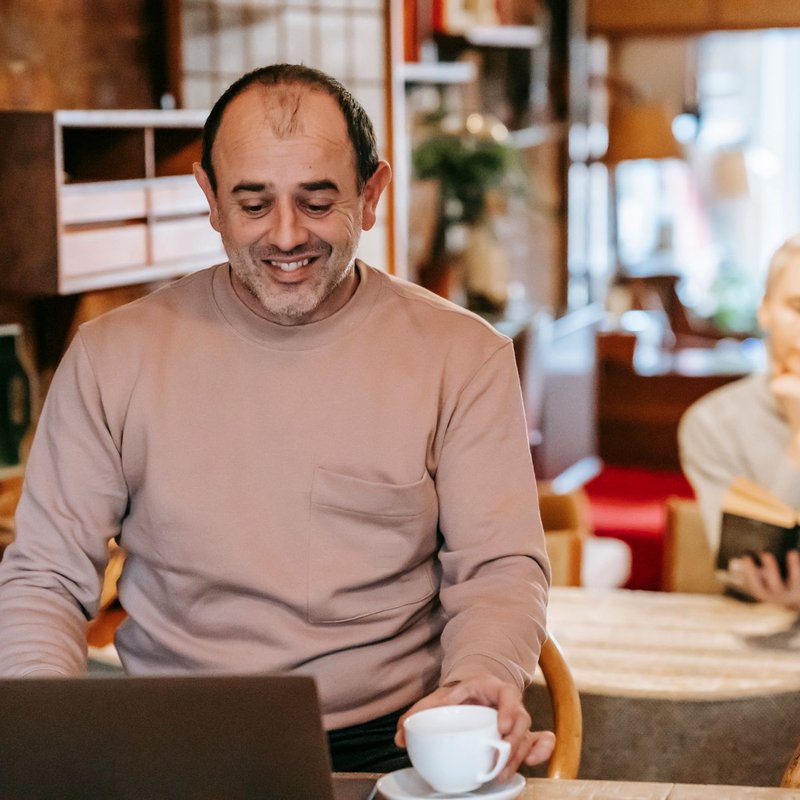 A man smiling at his laptop